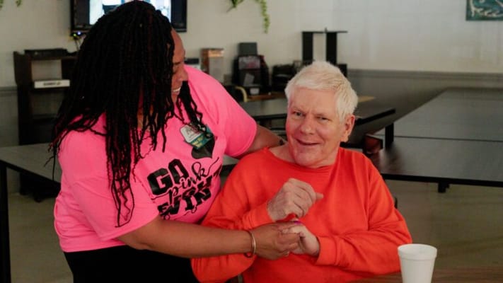 Staff member assisting a resident with a smile