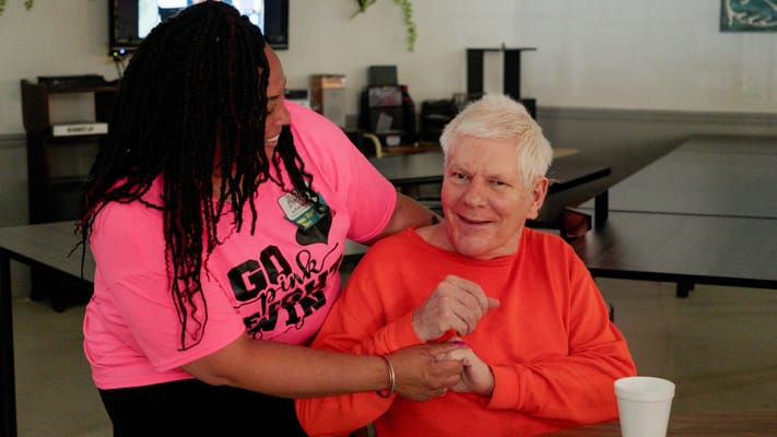 Staff member assisting a resident with a smile