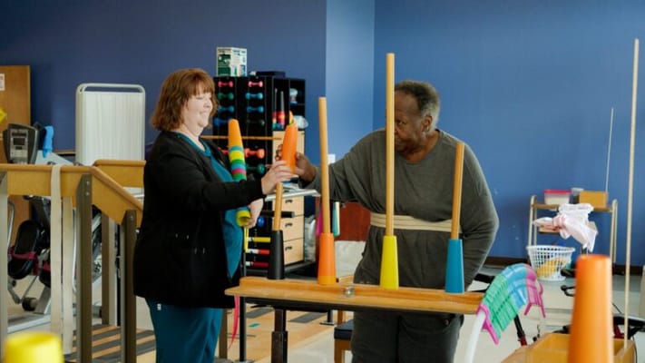 Therapist assisting a resident in an activity room