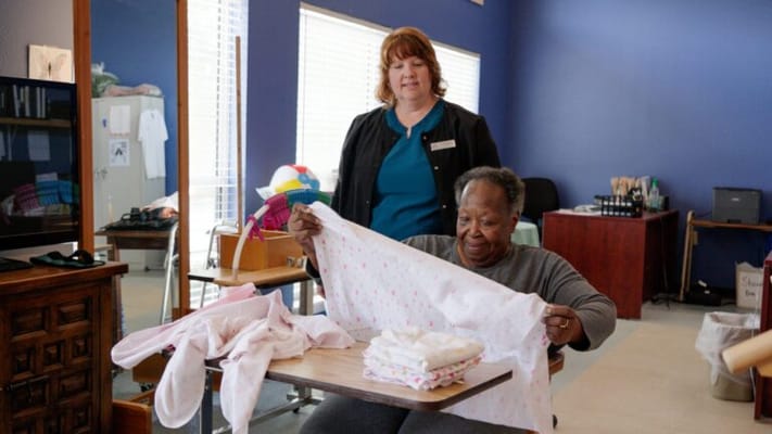 Staff assisting resident with laundry activities