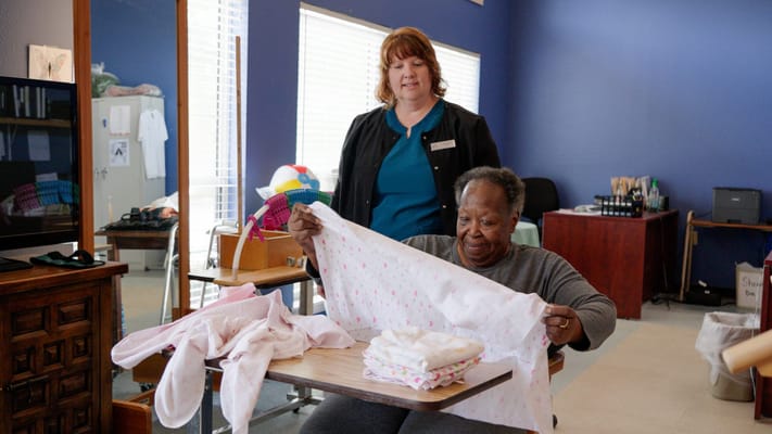Staff assisting resident with laundry activities