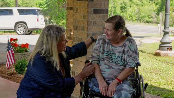 A staff member interacting with a resident outside.