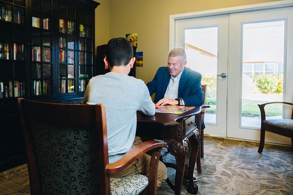 Resident and staff member playing a game inside