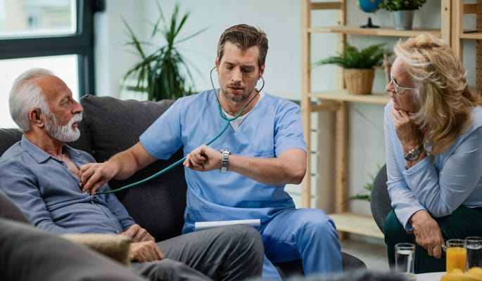 Health care professional attending to a senior resident indoors