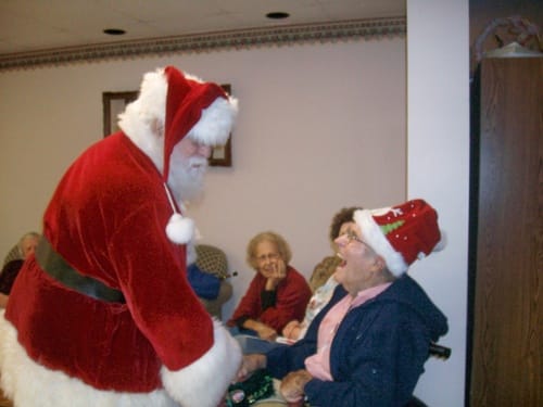 Resident enjoying a visit from Santa in a festive common area
