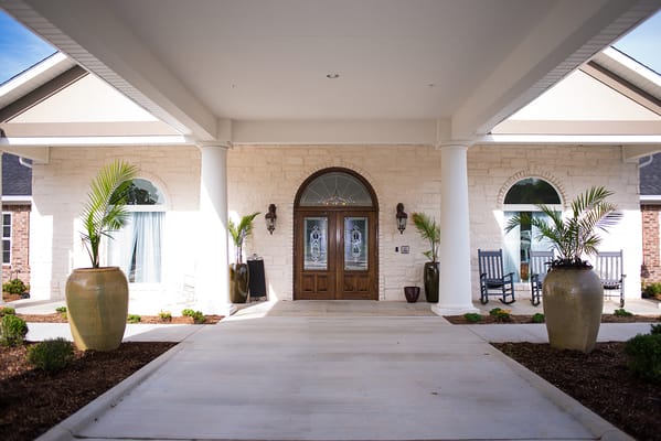 Entrance of a modern assisted living facility with decorative planters