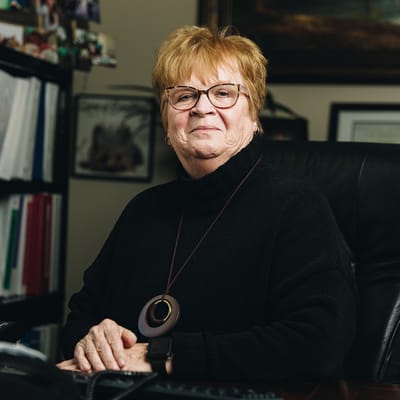Resident sitting in an office chair with a warm smile