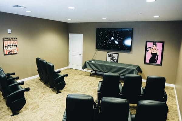 Interior of a media room with chairs and TV
