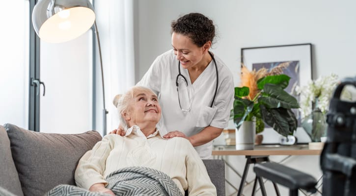 Nurse assisting an elderly resident in a cozy living area