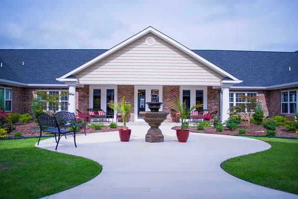 Front entrance of a senior living facility with landscaped path