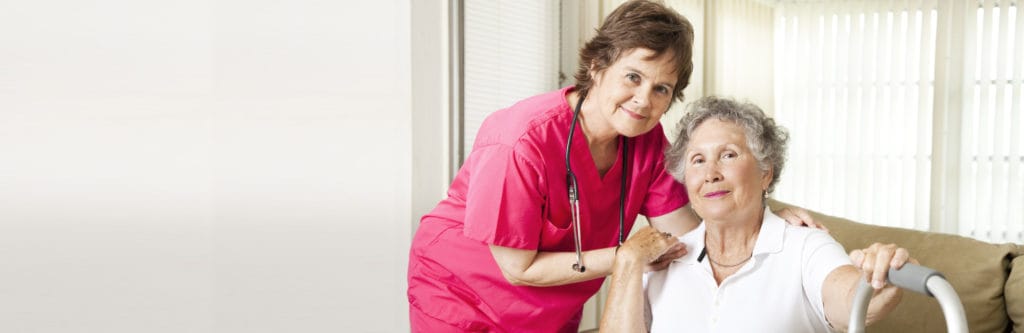 A caregiver assisting a senior resident in a living room