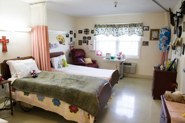 A private resident room with two beds and personal items