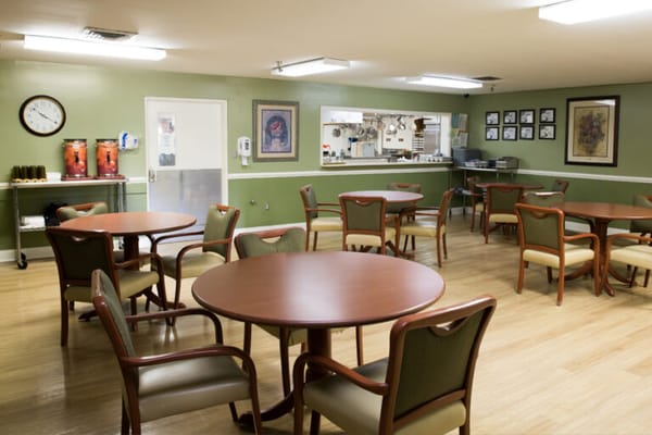 Dining area with tables and chairs in green-painted room