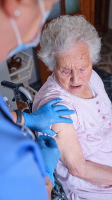 Healthcare worker administering a vaccine to a resident