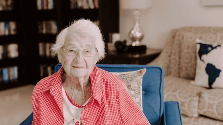 An elderly resident smiling in a cozy living room