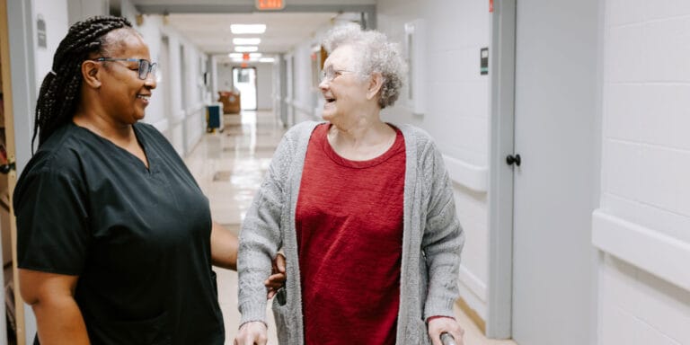 Staff assisting a resident in a hallway