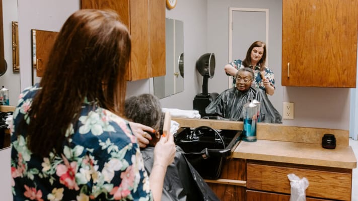 A resident getting a haircut in a salon