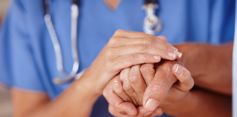 Close-up of healthcare provider holding a patient's hands