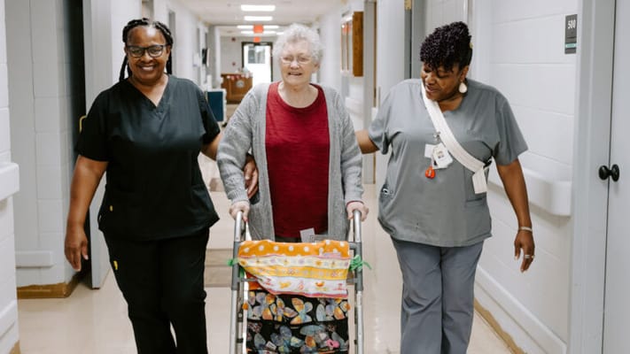 Staff assisting a resident in a hallway