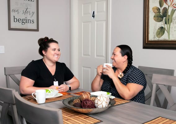 Staff and resident enjoying conversation over coffee