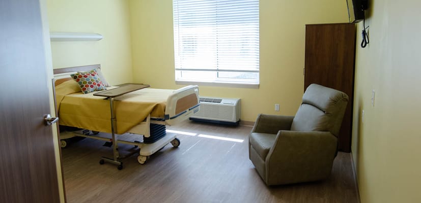 Private resident room with a bed and chair