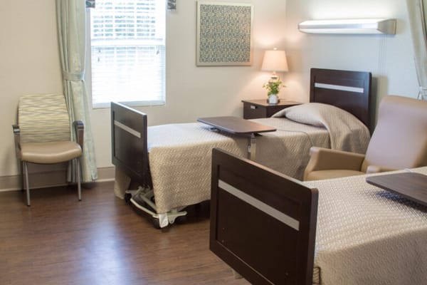 A private resident room with two beds and warm lighting