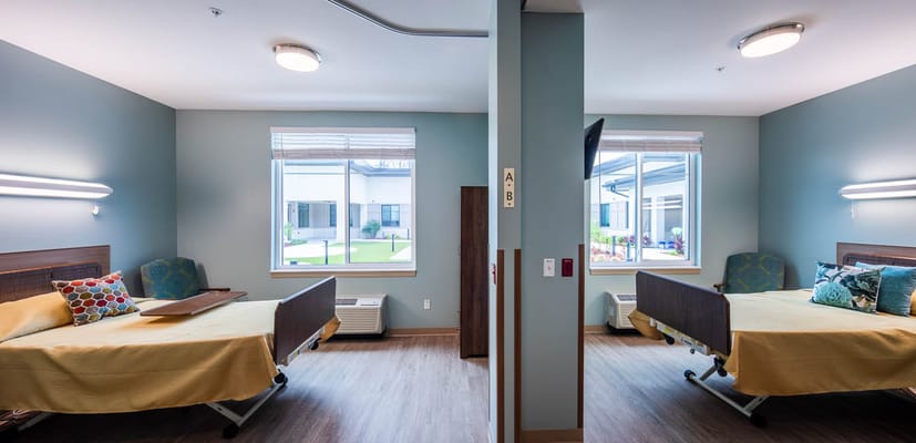 A shared resident room with two beds and windows