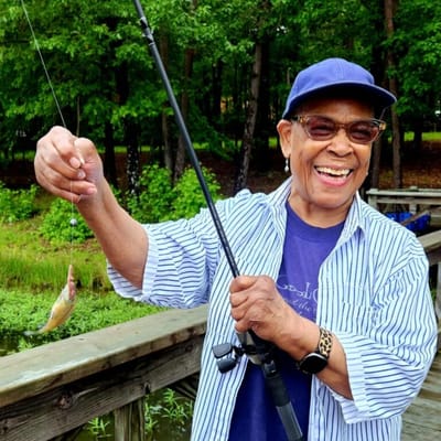 Resident fishing and smiling by the water