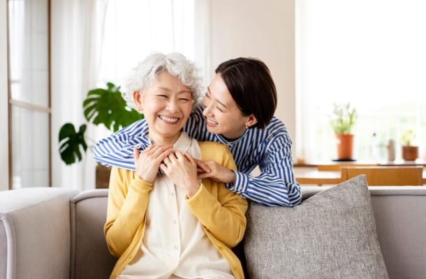 Two women sharing a joyful moment in a bright living room