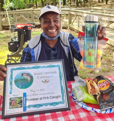 Resident celebrating a fishing derby with certificate and snacks