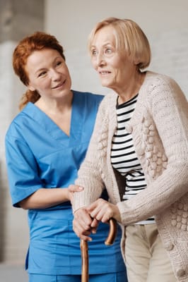 A staff member assisting a resident indoors