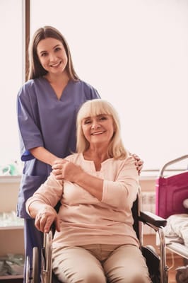A caregiver and resident posing together in a care facility