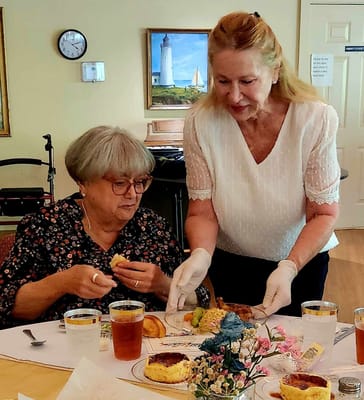 Staff serving food to residents in a dining room