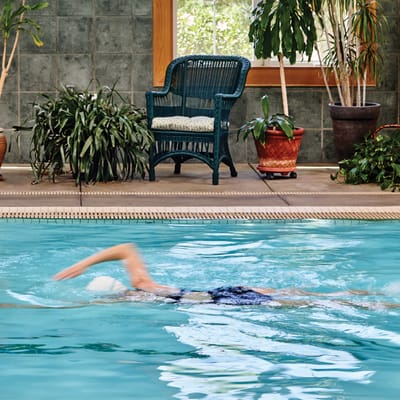 Resident swimming in an indoor pool with plants