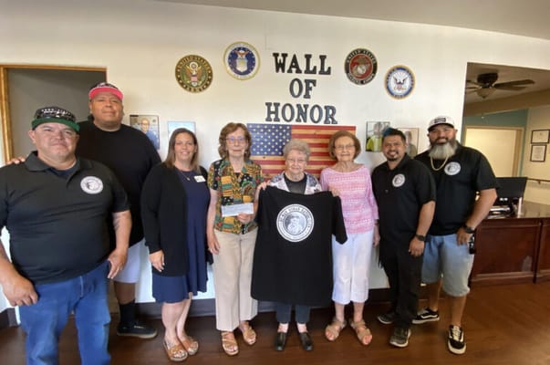 Residents and staff gather near the Wall of Honor