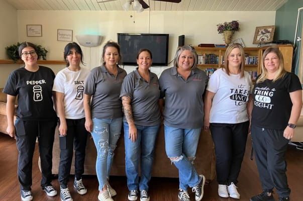 Staff members posing together in a common area