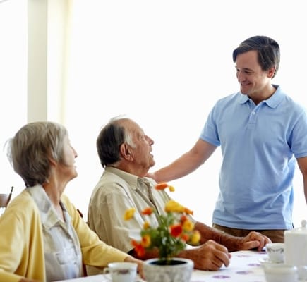 Staff member interacting with residents in a cozy common area