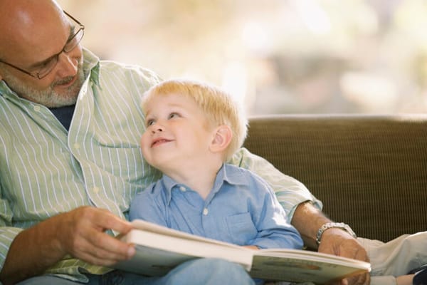 Grandfather reading with his grandson in a cozy interior