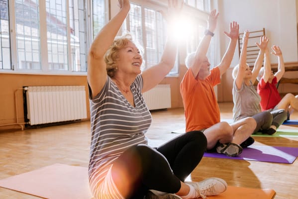 Seniors participating in a group exercise class indoors