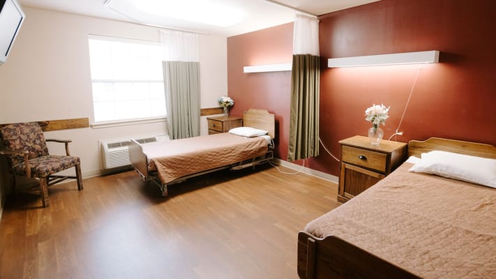 A shared resident room with two beds and furniture