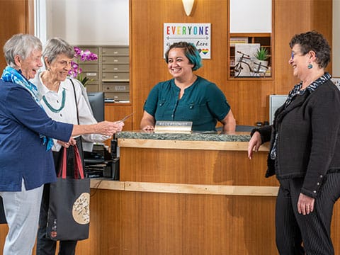 Residents engaging with staff at the reception desk