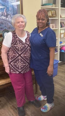 Resident and staff member smiling together in a common area