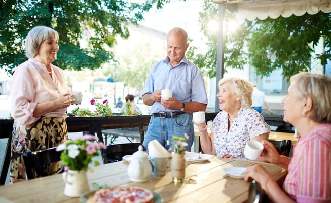 Residents enjoying coffee outdoors at a social gathering