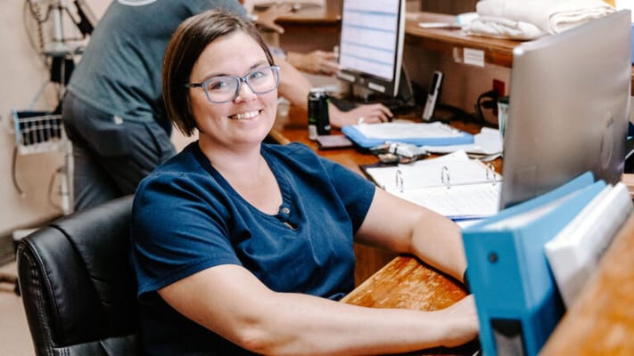 Staff member smiling at the reception desk