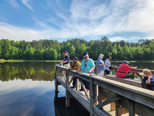 Residents fishing on a dock by a serene lake