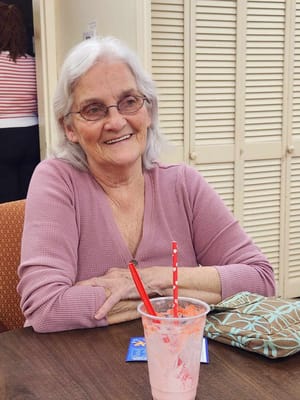 Resident enjoying a smoothie in a cozy setting
