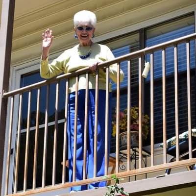 Resident waving from a balcony