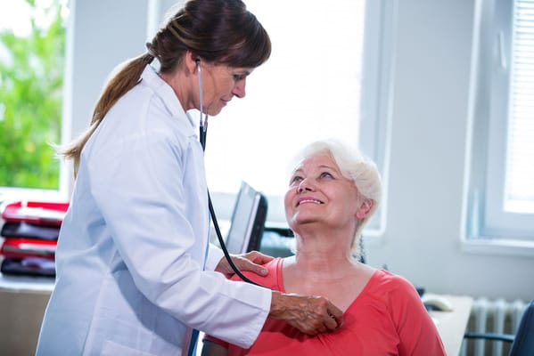 Healthcare professional assisting a senior resident