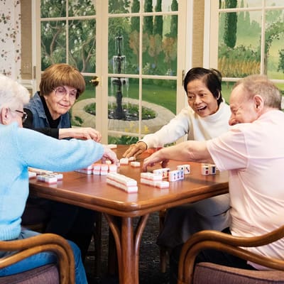 Residents enjoying a game of mahjong in a common area
