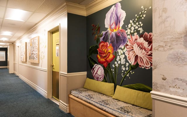 Interior hallway with colorful floral mural and seating